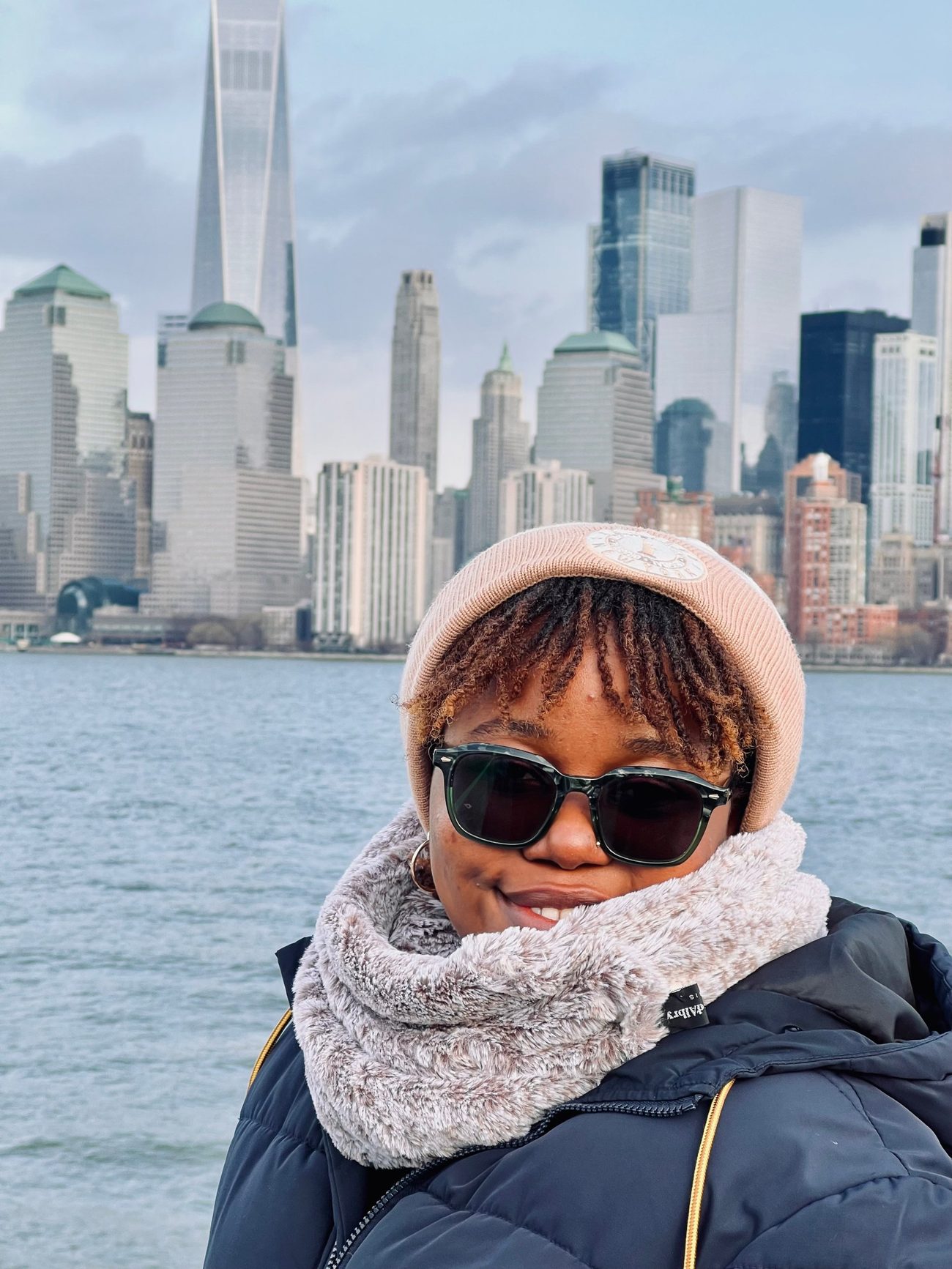 Cynthia on the water with the Manhattan skyline behind her